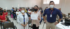A nutricionista Fabiane Crul Goldschmidt e o técnico de Relações com o Mercado do Senac Paraná, Josimar Paiva Espindola, entregam o certificado da palestra para a profissional Roseli Busata.